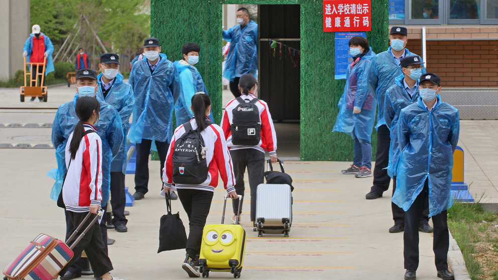 Police officers wearing face masks stand guard at an entrance to a middle school as students return to campus following the coronavirus disease (COVID-19) outbreak, in Yantai, Shandong province, China May 8, 2020. China Daily via REUTERS ATTENTION EDITORS - THIS IMAGE WAS PROVIDED BY A THIRD PARTY. CHINA OUT.