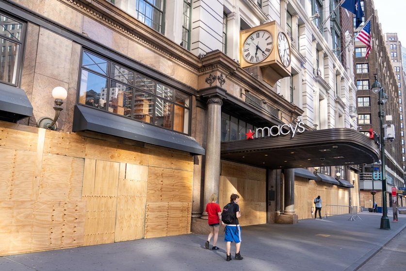 People walk by a boarded up Macy&#39;s flagship store in Herald Square on the first day of the city reopening. Photo: Ron Adar/SOPA Images via ZUMA Wire/dpa