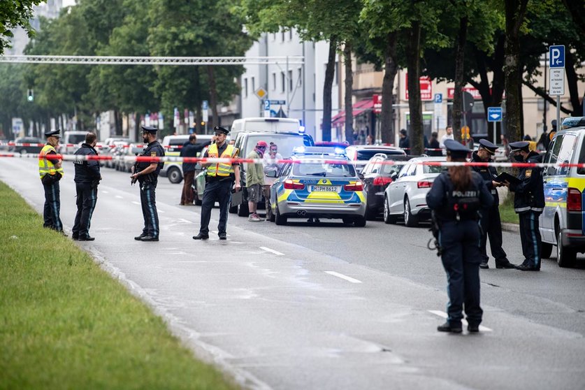 10 June 2020, Bavaria, Munich: Police officers stand near the scene, where a vehicle drove into a group of people. The car passengers then attacked the group they had driven into. Three were injured, either from the impact or in the subsequent brawl. Photo: Matthias Balk/dpa