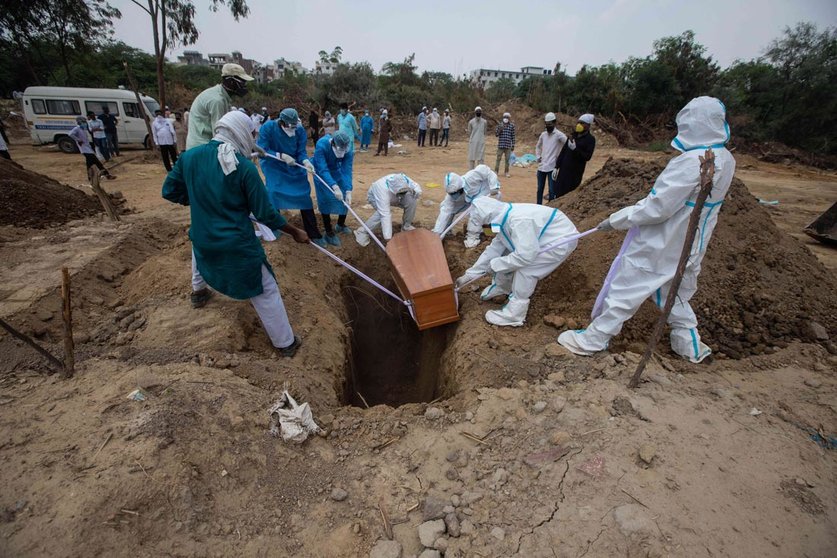 10 June 2020, India, New Delhi: Medical workers and relatives wearing personal protective equipment gear buried a person who died of coronavirus (Covid-19) at the Jadid Qabristan Ahle Islam graveyard. Photo: Vijay Pandey/ZUMA Wire/dpa