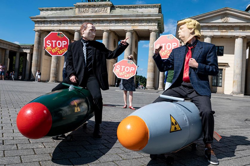 30 July 2020, Berlin: Two activists disguised as US President Donald Trump and Russian President Vladimir Putin ride two models of nuclear bombs in front of the Brandenburg Gate during a demonstration for a world without nuclear weapons. Photo: Fabian Sommer/dpa