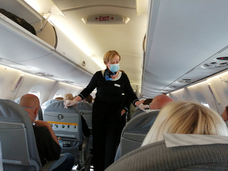15 July 2020.  A cabin crew member, wearing a mask and gloves, on a Finnair flight in 2020. Photo: © The Nomad Today.