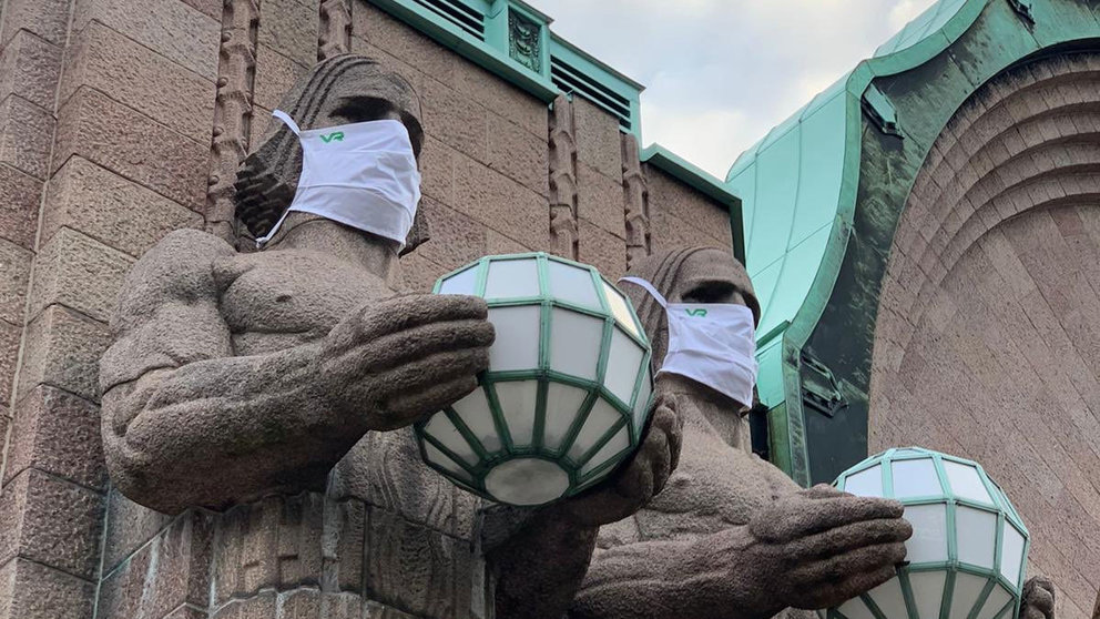The stone men who guard the entrance to Helsinki&#39;s main station, equipped with masks. Photo: VR.