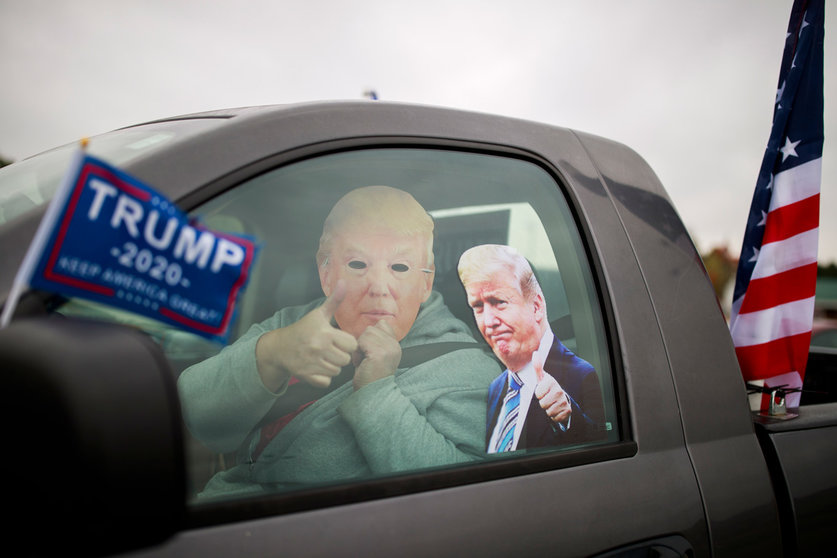 10 October 2020, US, Martinsville: A man wears a mask of US President Donald Trump during cars parade to support Trump. Photo: Jeremy Hogan/dpa.