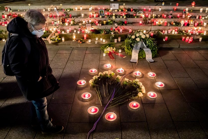 19 December 2020, Berlin: A woman wears a face mask looks at the candles and white roses laid in the shape of a heart at the "Golden Rift" memorial during the commemoration on the fourth anniversary of the Islamist attack on the Breitscheidplatz Christmas market. where On 19 December 2016, a truck was deliberately driven into the Christmas market next to the Kaiser Wilhelm Memorial Church at Breitscheidplatz in Berlin, leaving 12 people dead and 56 others injured. Photo: Christoph Soeder/dpa
