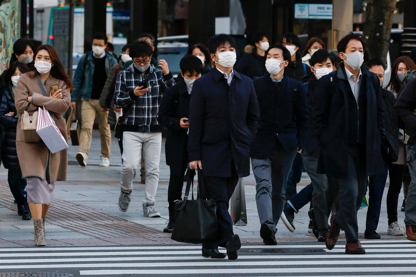 16 December 2020, Japan, Tokyo: People wearing face masks walk around the Ginza shopping district. Tokyo reached a new single-day record of 678 new coronavirus (COVID-19) cases on Wednesday. Photo: Rodrigo Reyes Marin/dpa.
