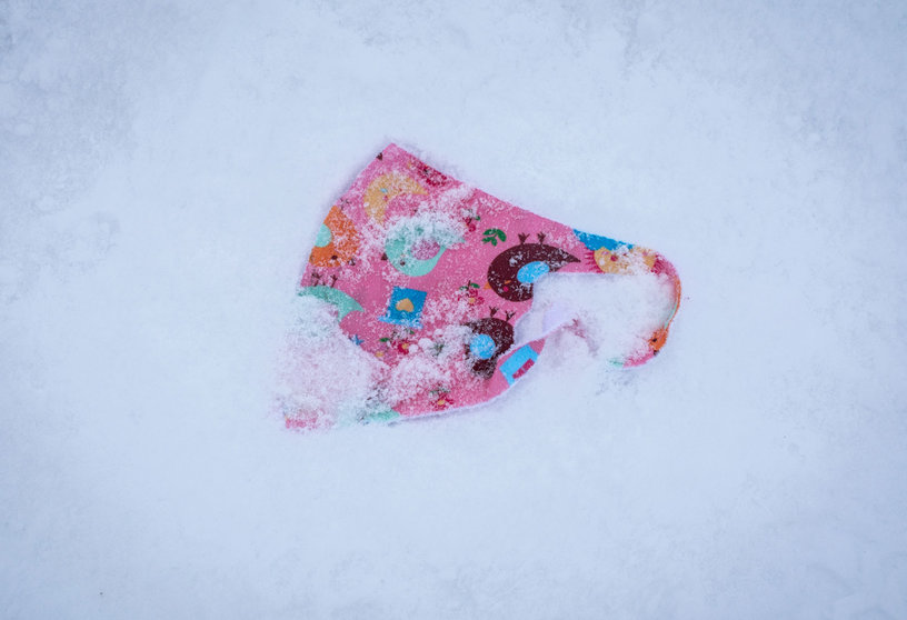 11 December 2020, Hessen, Grosser Feldberg: A patterned face mask lies in the snow on the summit plateau of the Grosser Feldberg mountain. Photo: Frank Rumpenhorst/dpa