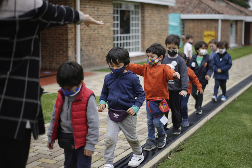 09 February 2021, Colombia, Bogota: A teacher tries to teach young children with masks on how to keep their distance from each other amid the Corona pandemic after partial attendance classes resumed in 907 schools in the Colombian capital. Photo: Alvaro Tavera/colprensa/dpa