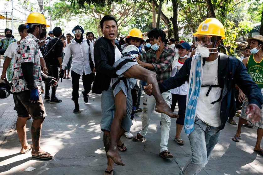 FILED - 19 March 2021, Myanmar, Yangon: Demonstrators carry a wounded man during clashes at a protest against the military coup and the detention of civilian leaders. Photo: Aung Kyaw Htet/SOPA Images via ZUMA Wire/dpa