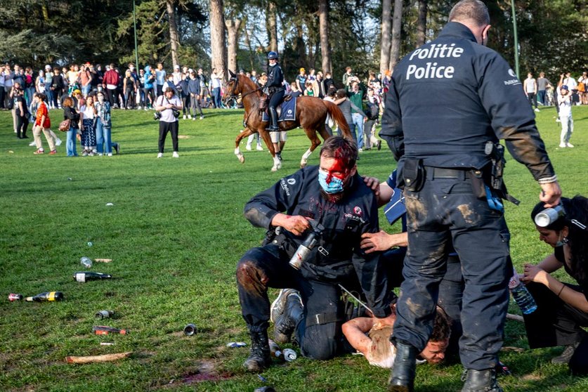 01 April 2021, Belgium, Brussels: An injured policeman arrests a protester at the Bois de La Cambre - Ter Kamerenbos as Brussels local police start the evacuation of the Park. Photo: Hatim Kaghat/BELGA/dpa