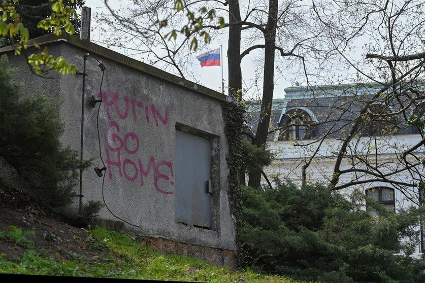 22 April 2021, Czech Republic, Prague: The Russian flag waves on top of the Russian embassy in Prague near a construction with graffiti ready "Putin, Go Home". Photo: Kamaryt Michal/CTK/dpa