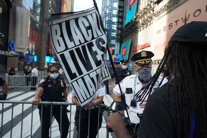FILED - A woman holds a Black Lives Matter flag as she speaks with police officers during a Black Lives Matter protest at Times square following the death of George Floyd, an African American man who was killed on 25 May while in police custody in the US city of Minneapolis. Photo: Bryan Smith/ZUMA Wire/dpa