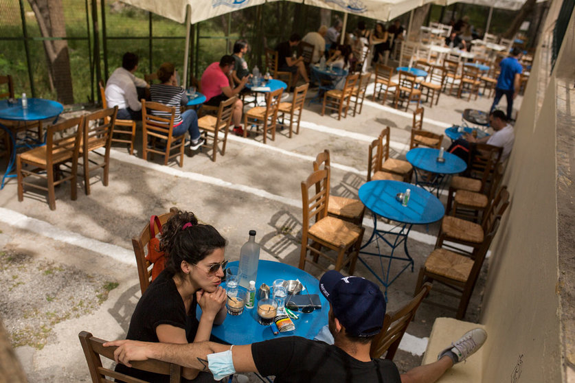 03 May 2021, Greece, Athens: People sit in a cafe in the Monastiraki district with the Acropolis in the background. Greece relaxes the measures imposed because of the Coronavirus pandemic. Photo: Socrates Baltagiannis/dpa