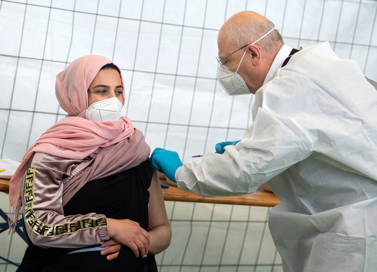 14 May 2021, Berlin: A woman receives a Johnson & Johnson vaccine against Coronavirus by Dr. Fatmir Dalladaku in the gym of a school in Neukoelln, where a focus vaccination against Corona is taking place. Photo: Bernd von Jutrczenka/dpa