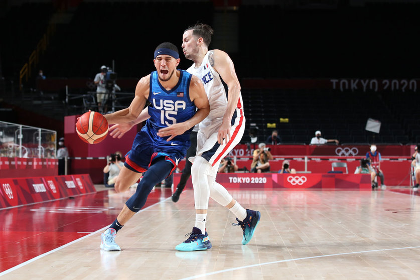25 July 2021, Japan, Saitama: USA's Devin Booker (L) and France's Thomas Heurtel battle for the ball during the Men's Preliminary Round Group A basketball match between France and the United States at the Saitama Super Arena, held as part of the Tokyo 2020 Olympic Games. Photo: Mickael Chavet/ZUMA Press Wire/dpa