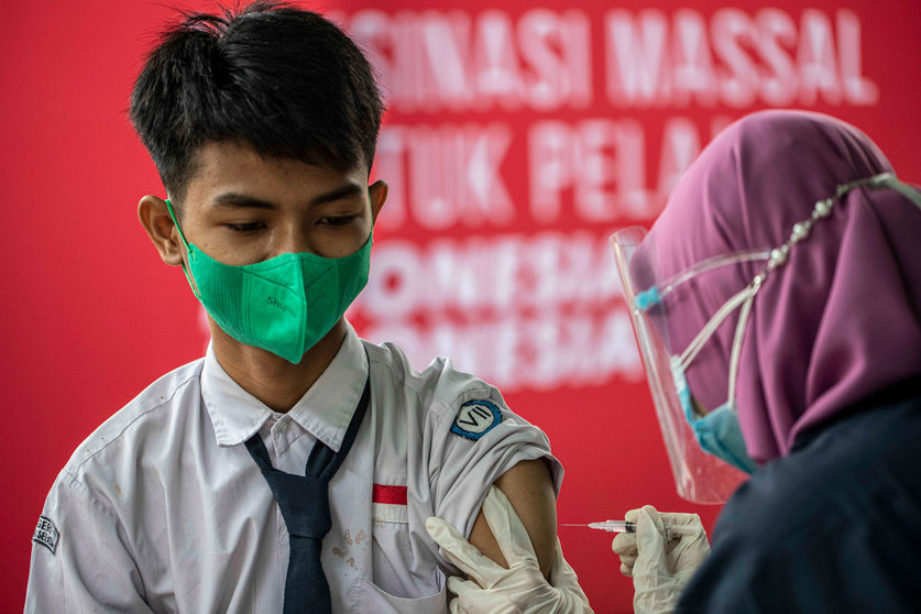 A healthcare worker injects a child with a dose of a coronavirs vaccine during a mass vaccination campaign for school children aged 12 to 17 years at State Junior High School 11 South Tangerang. Photo: Donal Husni/ZUMA Wire/dpa