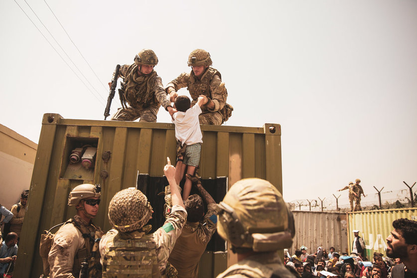 20 August 2021, Afghanistan, Kabul: British, Turkish and US soldiers assist a child during the evacuation of civilians at Hamid Karzai International Airport. Photo: Ssgt. Victor Mancilla/U.S. Marin/Planet Pix via ZUMA Press Wire/dpa
