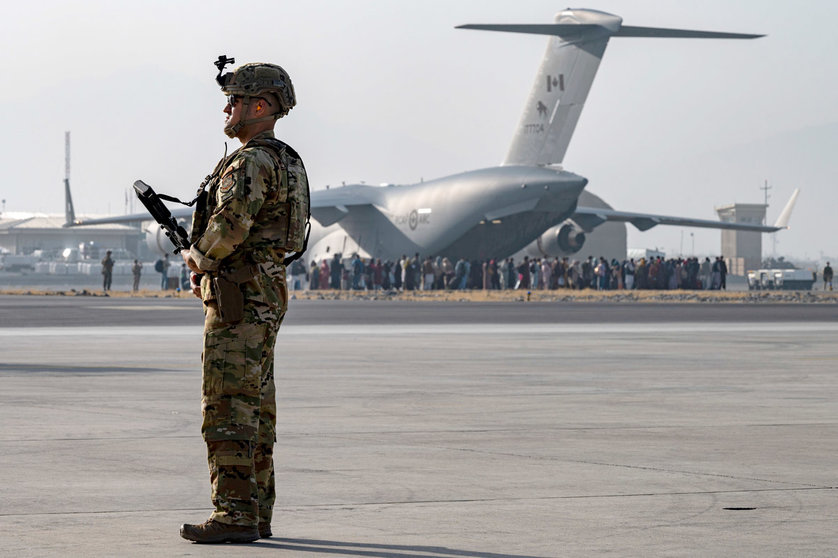 20 August 2021, Afghanistan, Kabul: A US Air Force soldier stands guard as evacuees are loaded onto a C-17 Globemaster III aircraft during the evacuation process at Hamid Karzai International Airport. Photo: Sra Taylor Crul/U.S. Air/Planet Pix via ZUMA Press Wire/dpa