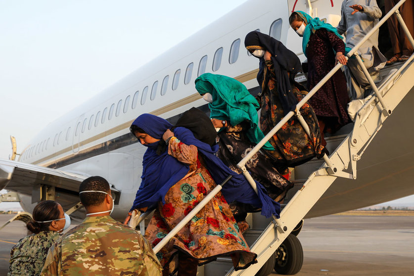 HANDOUT - 26 August 2021, Italy, Sigonella: Servicemen assist Afghan evacuees as they disembark a plane at the Sigonella Naval Air Station Airport in the midst of the Taliban takeover. Photo: Mc2 Claire Dubois/U.S. Navy/Planet Pix via ZUMA Press Wire/dpa - ATTENTION: editorial use only and only if the credit mentioned above is referenced in full