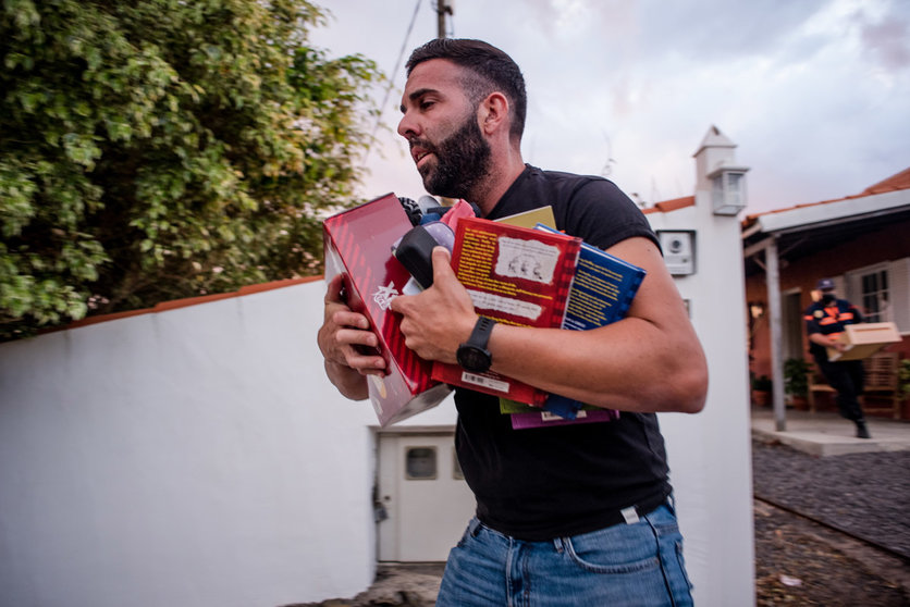 20 September 2021, Spain, La Palma: A man carries books from a house during the evacuation due to the volcano eruption. For the first time in 50 years, a volcano has erupted again on the Spanish Canary Island of La Palma. Photo: Arturo Jiménez/dpa