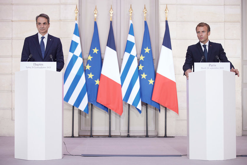 HANDOUT - 28 September 2021, France, Paris: Greek Prime Minister Kyriakos Mitsotakis (L) and French President Emmanuel Macron speak during a press conference after the signing ceremony of a new defence deal at The Elysee Palace. France and Greece signed an important defence agreement on Tuesday that includes commitments from Athens to buy three French warships, with an option to buy a fourth. Photo: Dimitris Papamitsos/Prime Minister's Office/dpa - ATTENTION: editorial use only and only if the credit mentioned above is referenced in full