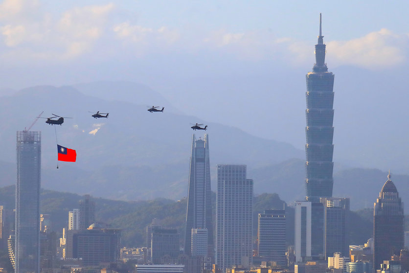 05 October 2021, Taiwan, New Taipei City: A military helicopter carrying a tremendous Taiwan flag conducts a flyby rehearsal with other helicopters ahead of the Double-tenth National Day celebration, near Taipei 101, amid China's growing military threats. Photo: Daniel Ceng Shou-Yi/ZUMA Press Wire/dpa