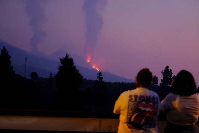 17 October 2021, Spain, La Palma: Two people look at one of the eruptive mouths of the Cumbre Vieja volcano on the Canary Island of La Palma. Photo: -/EUROPA PRESS/dpa