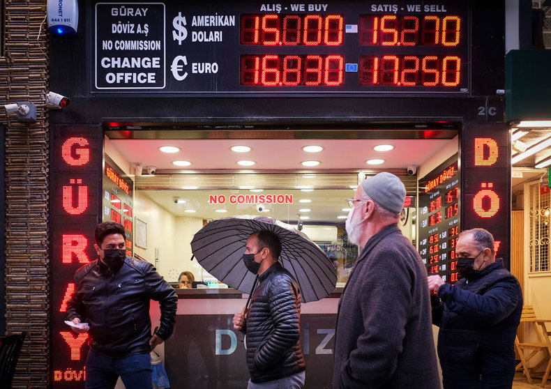 17 December 2021, Turkey, Istanbul: People walk in front of a currency exchange shop in Istanbul. The Turkish central bank cut its benchmark interest rate to 14 per cent on Thursday, the fourth consecutive cut since September, leading the lira to fall to historic lows. Photo: Serkan Senturk/ZUMA Press Wire/dpa.