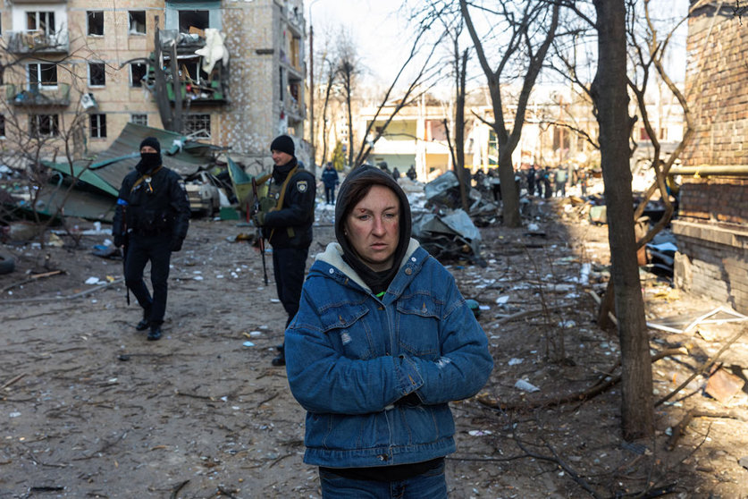 18 March 2022, Ukraine, Kiev: A woman walks past an apartment building damaged by Russian shelling in the Podil neighborhood. Photo: Mykhaylo Palinchak/SOPA Images via ZUMA Press Wire/dpa.