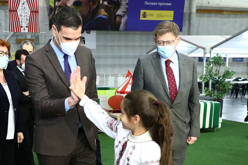03/31/2022. Prime Minister Pedro Sanchez (L) greets a girl staying at the Reception, Care and Referral Center for Ukrainian refugees in the City of Light (Alicante), in the presence of the president of the Generalitat Valenciana, Ximo Puig. Photo: Moncloa.